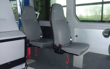 Gulv med sort, fuldlimet tæppe. 4 drejeklapstole, Jany type 862. Elkørestolslås for kørestol uden passager.