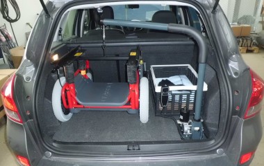 Kørestolskran med løftekapacitet på 35 kg monteret i bagagerum for løft af Carony Classic kørestolsunderstel.